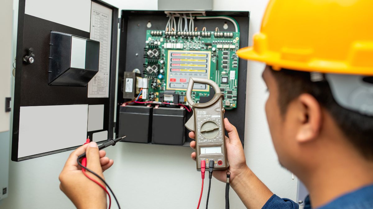 Technik kontroluje digitálny elektromer pomocou multimetra na meranie.