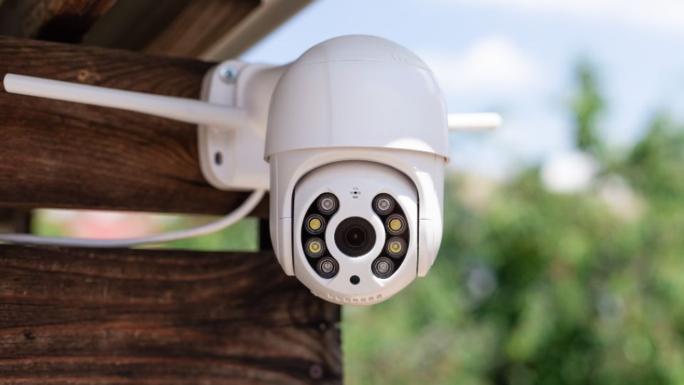 IP kamera umiestnená na drevenej konštrukcii, pripravená na monitorovanie vonkajšieho prostredia.