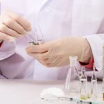 Laboratórne práce s chemikáliami, skúmavky a injekčné striekačky.