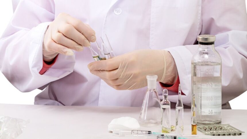 Laboratórne práce s chemikáliami, skúmavky a injekčné striekačky.