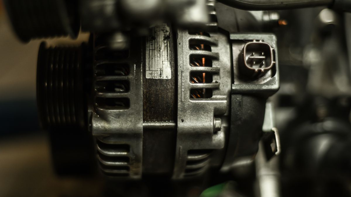 Detail alternátora v automobile, zobrazený z blízka s elektrickými komponentmi.