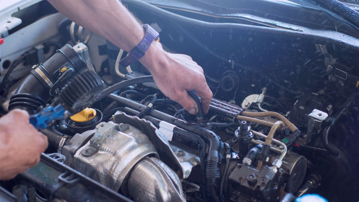 Mechanik pracuje na motorovom priestore vozidla, kontroluje a opravuje súčiastky.