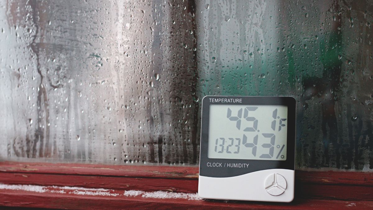 Teplomer ukazujúci 45,1 °F a 43 % vlhkosti na okne s kondenzáciou.