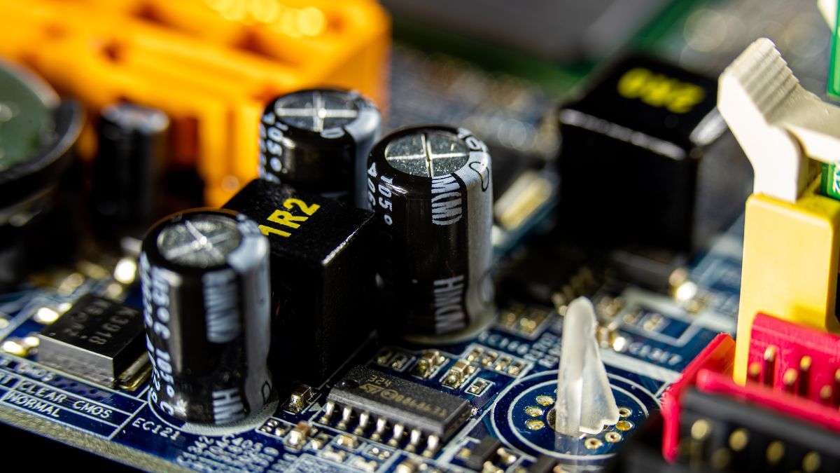 Detailný pohľad na kondenzátory na elektronickej doske, ukazujúci ich rôzne typy a umiestnenie.