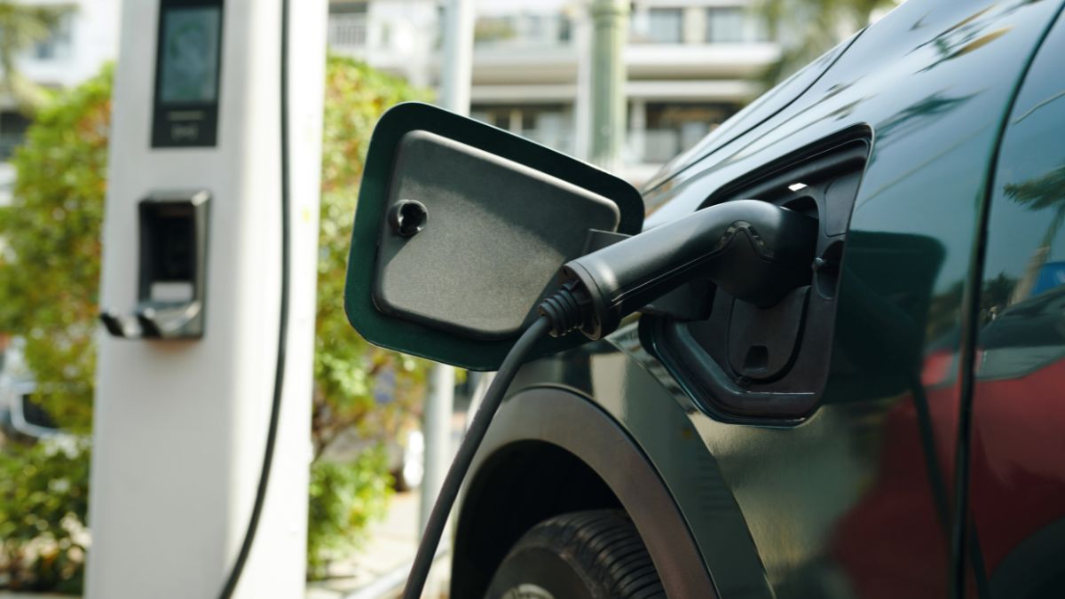 Detail nabíjacej pištole pripojenej k elektromobilu na nabíjacej stanici.