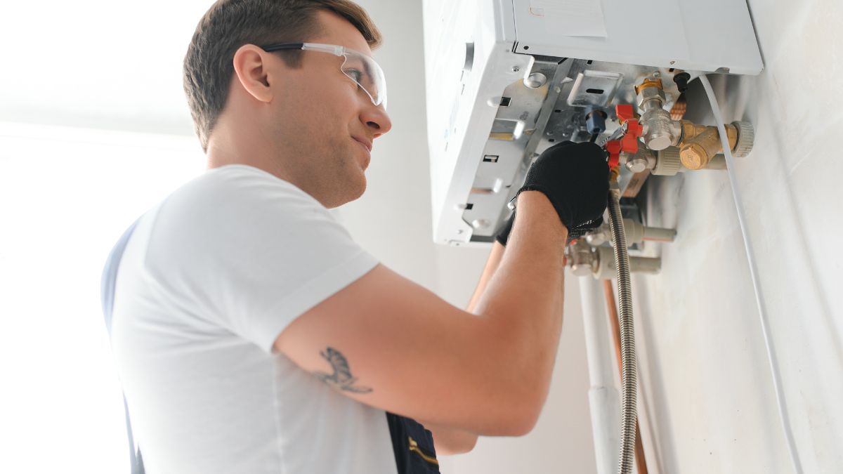 Technik kontroluje kondenzačný kotol na stene, zameraný na optimalizáciu vykurovania.