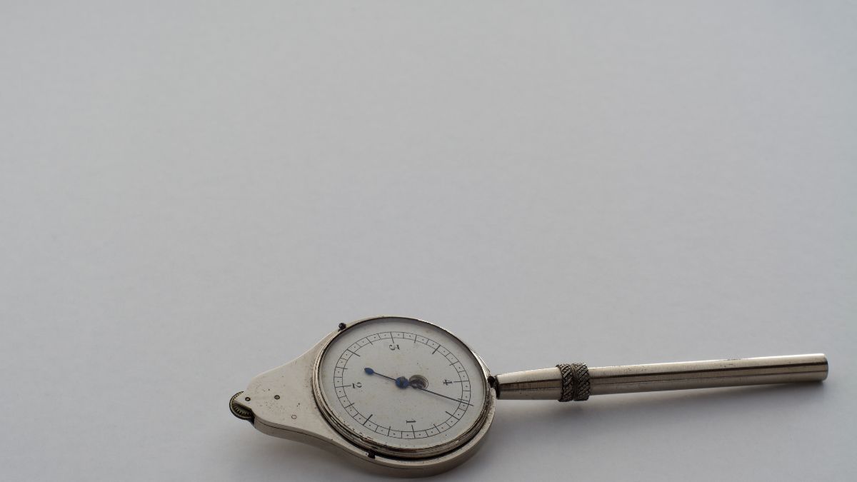 Rotameter s bielym ciferníkom a kovovým telom na meranie prietoku.