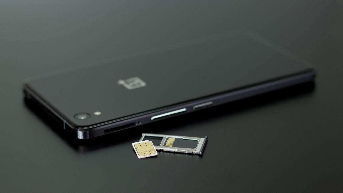 Čierny dual SIM telefón s vyberateľnou SIM kartou na čiernom pozadí.