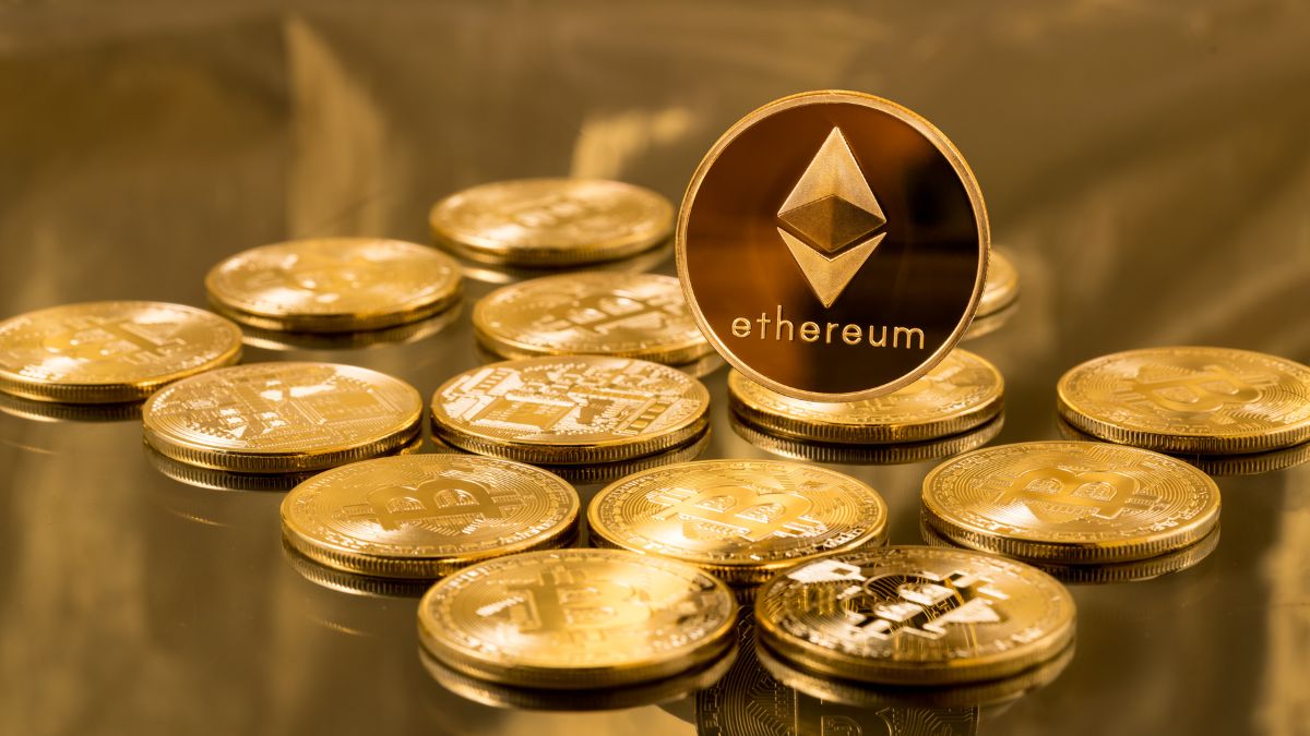 Zlatá minca Ethereum v popredí s ďalšími kryptomenami na pozadí.