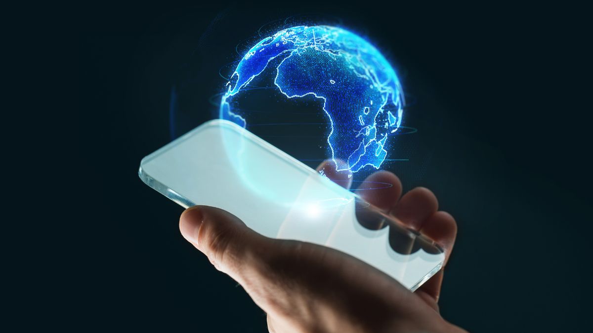 Ruka drží smartfón, z ktorého vyžaruje hologram Zeme v 3D.