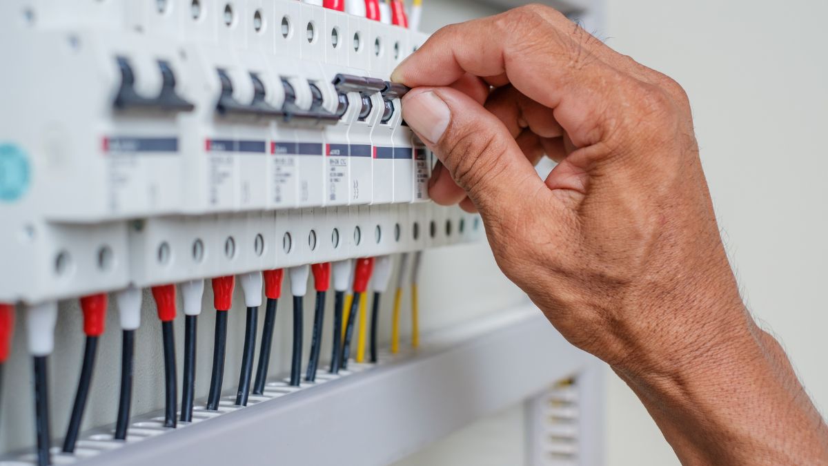 Ruka nastavuje istič v elektrickej rozvodnej skrini na ochranu domácnosti.