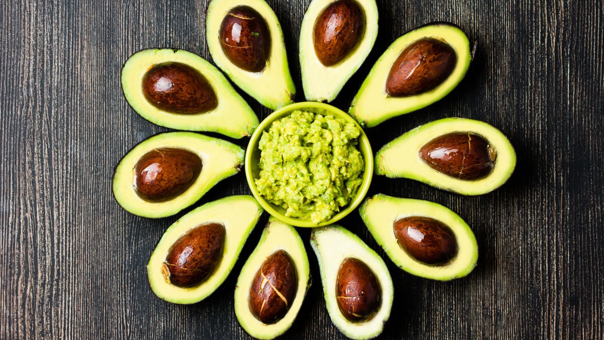 Svieže avokádo rozložené do tvaru kvetu s miskou guacamole v strede.
