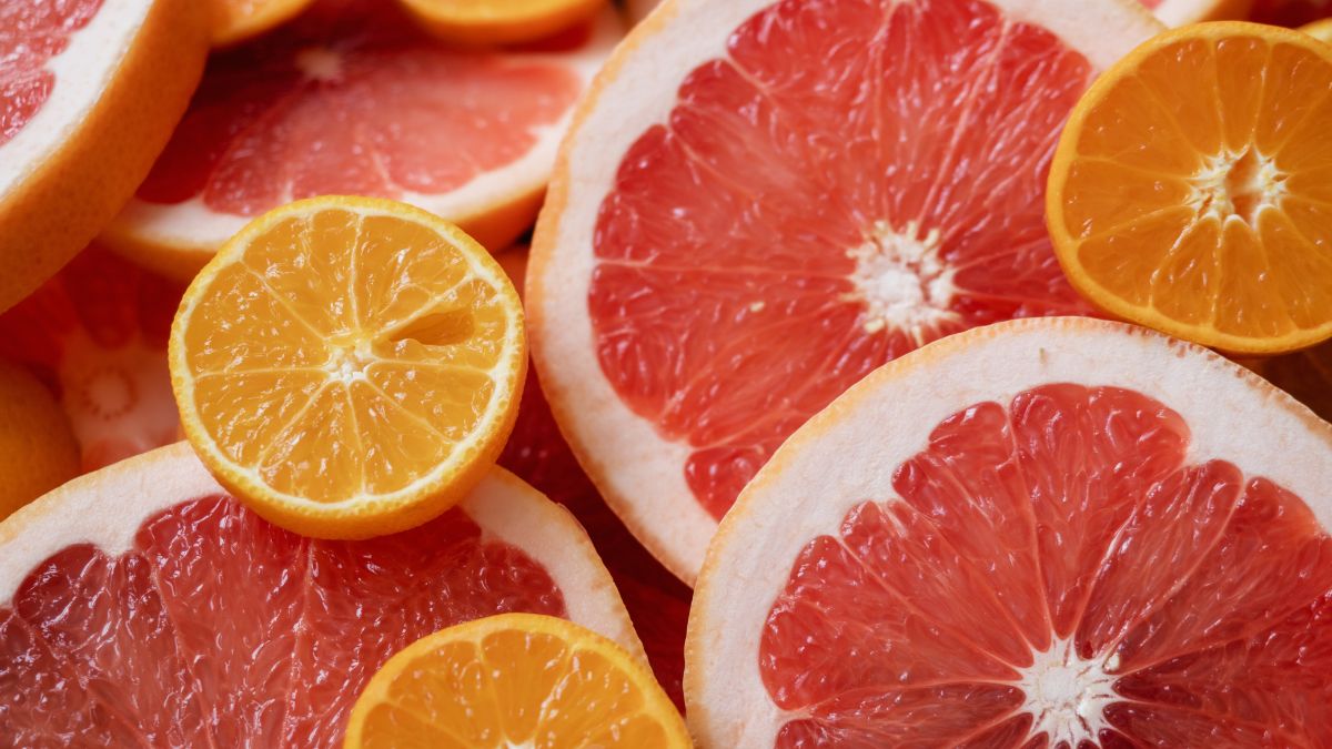 Plátky grapefruitu a pomaranča na svetlom pozadí, symbolizujúce detoxikáciu.