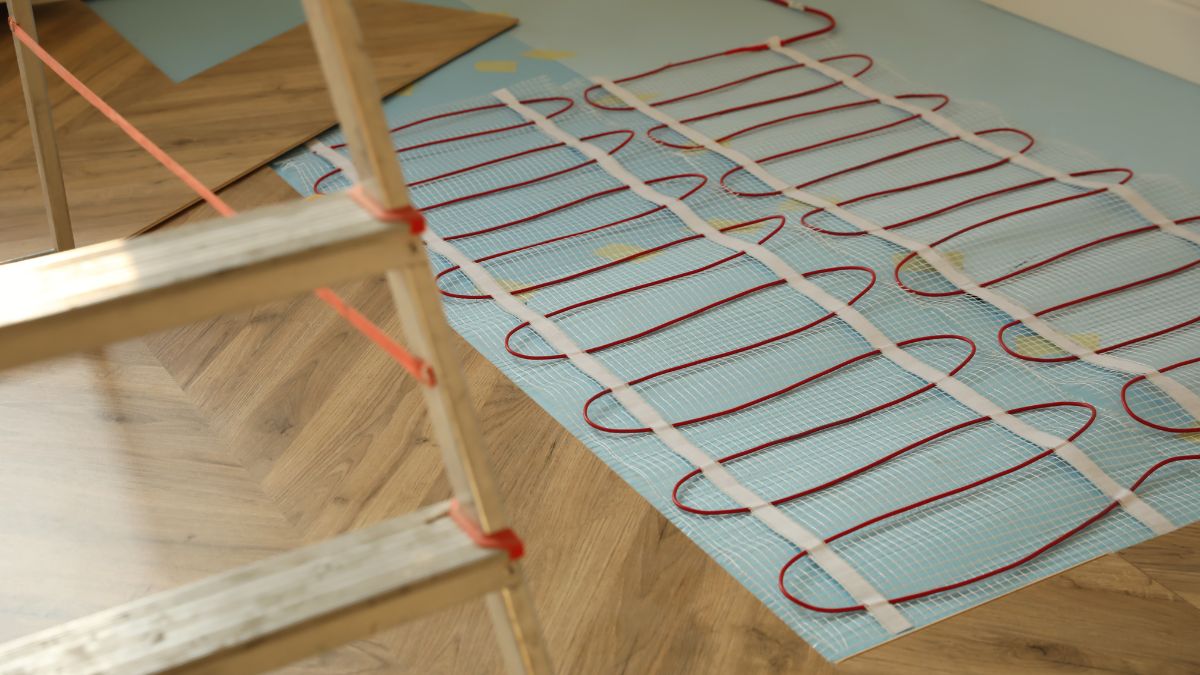 Na podlahe sú vidieť elektrické podlahové kúrenie s červenými káblami.