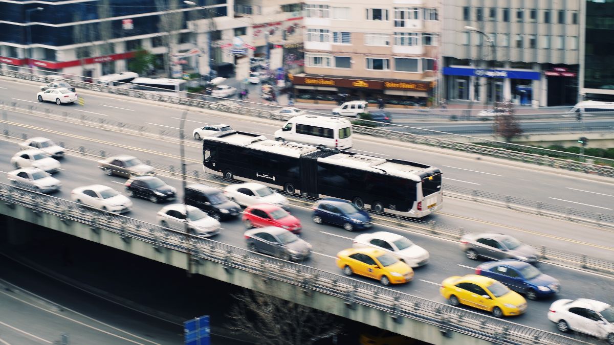 Doprava v meste s autobusom a autami na rušnej ceste.