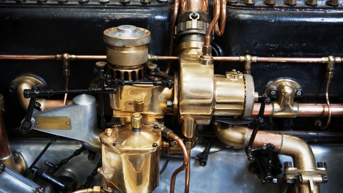 Detailný pohľad na karburátor motora s medenými trubkami a mechanizmami.