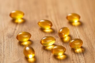 Olejové kapsuly vitamínu D na drevenom pozadí