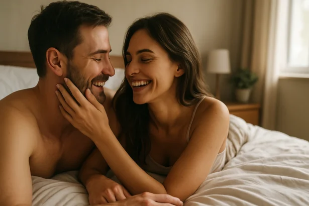 Šťastný pár sa smeje a užíva si spoločný čas v posteli.