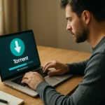 Muž pracujúci na počítači s torrent klientom na obrazovke