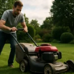 Muž kosenie trávnika s kosačkou na zelenej tráve.