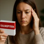 Žena s bolesťou hlavy, prezerajúca balenie Kalmopyrinu.