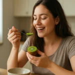Žena si vychutnáva kivi na raňajky, bohaté na vitamíny a antioxidanty.