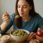 Žena vychutnáva zdravé jedlo bohaté na vlákninu s brokolicou a ovsenými vločkami.