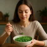 Žena si vychutnáva čerstvý hrášok zo misy