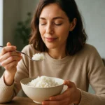 Žena vychutnáva si ryžu na tanieri, zdravý a chutný pokrm.