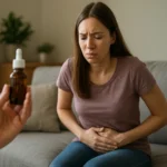 Žena s bolestivými príznakmi drží si brucho a pozerá na kvapky.