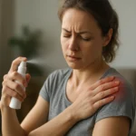 Žena používa sprej na bolesť na zmiernenie bolesti ramena.