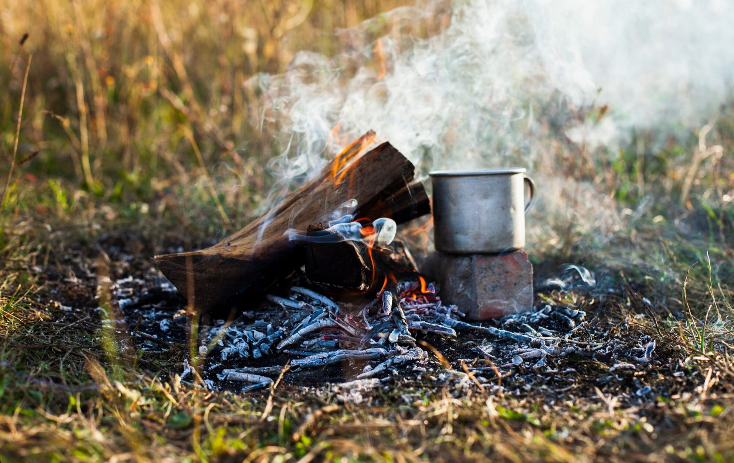 Oheň a hrnček varenia v prírode počas bushcraft aktivít.