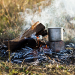 Oheň a hrnček varenia v prírode počas bushcraft aktivít.