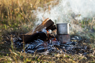 Oheň a hrnček varenia v prírode počas bushcraft aktivít.
